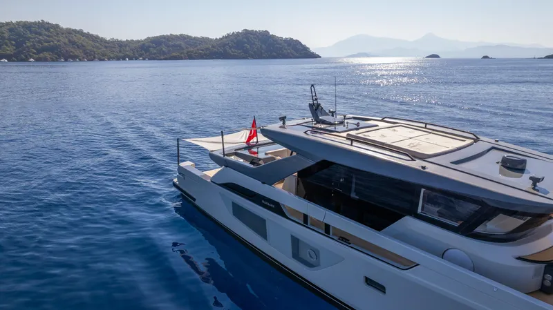 Mama Punch Yacht Photos Pics Bluegame BGX70 yacht cruising on serene waters, 2021 model, with scenic island backdrop.