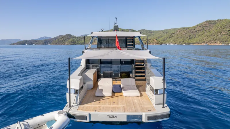 Mama Punch Yacht Photos Pics 2021 Bluegame BGX70 yacht on serene blue waters, featuring spacious deck and scenic backdrop.