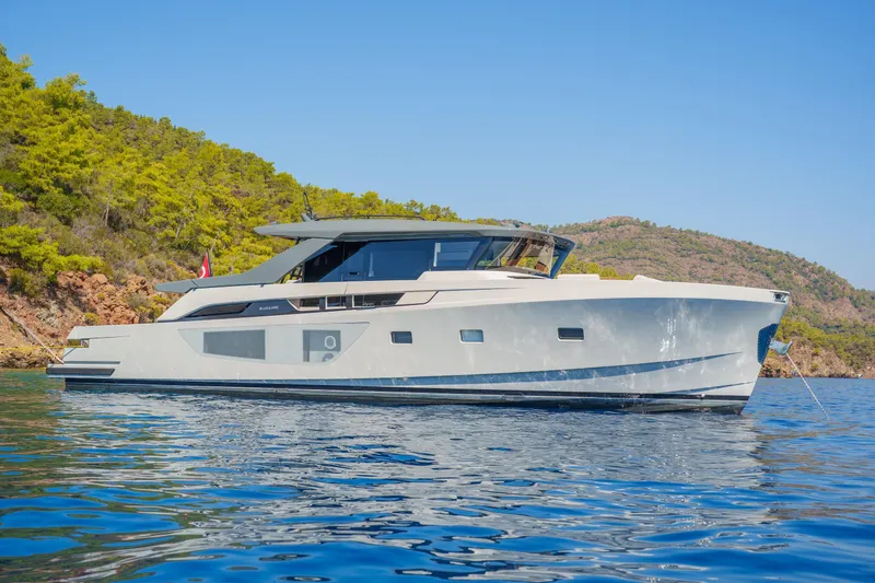 Mama Punch Yacht Photos Pics 2021 Bluegame BGX70 yacht cruising near a scenic coastline.
