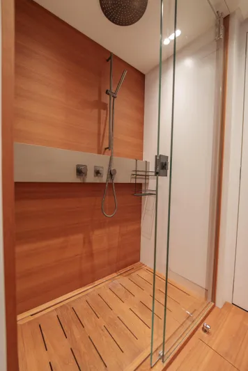 Mama Punch Yacht Photos Pics Luxurious wooden shower in 2021 Bluegame BGX70 yacht, featuring modern fixtures and glass door.