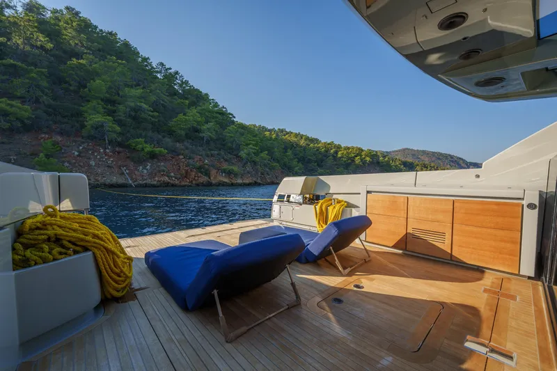 Mama Punch Yacht Photos Pics Luxurious 2021 Bluegame BGX70 yacht deck with lounge chairs, scenic coastal view.