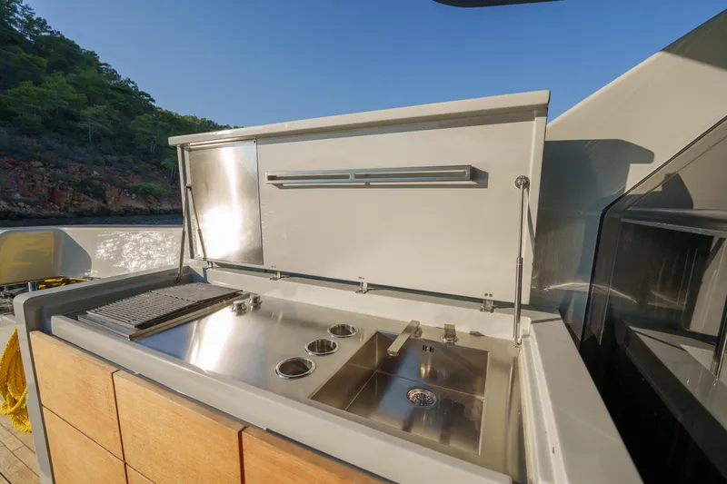 Mama Punch Yacht Photos Pics Outdoor kitchen on 2021 Bluegame BGX70 yacht with stainless steel appliances and scenic view.