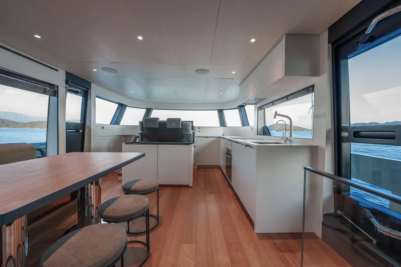 Mama Punch Yacht Photos Pics Luxurious interior of 2021 Bluegame BGX70 yacht with modern kitchen and dining area.