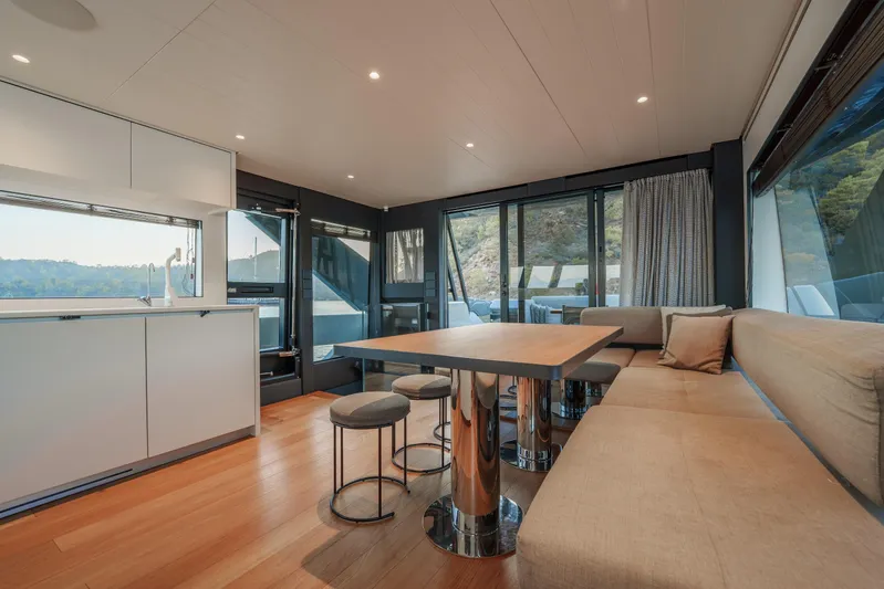 Mama Punch Yacht Photos Pics Luxurious interior of 2021 Bluegame BGX70 yacht with modern dining area and panoramic windows.