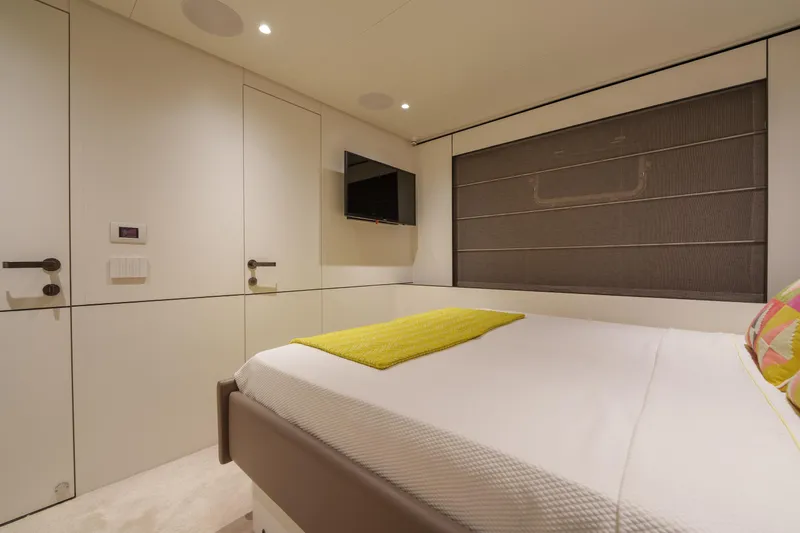 Mama Punch Yacht Photos Pics Modern bedroom interior on 2021 Bluegame BGX70 yacht, featuring a cozy bed and wall-mounted TV.