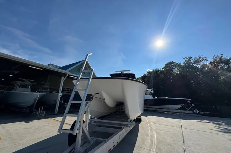  Yacht Photos Pics 2023 Invincible 35 Catamaran on trailer under bright sun, near storage facility.
