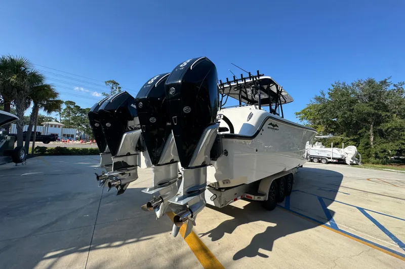  Yacht Photos Pics 2023 Invincible 35 Catamaran with triple outboard engines in a sunny outdoor setting.