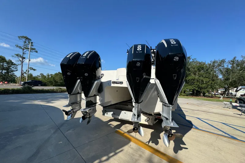  Yacht Photos Pics 2023 Invincible 35 Catamaran with triple outboard engines, parked outdoors under clear blue sky.