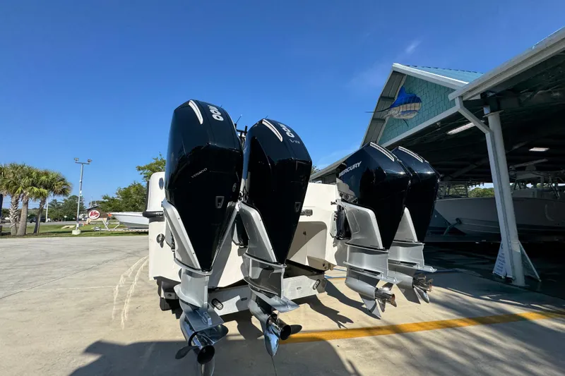  Yacht Photos Pics 2023 Invincible 35 Catamaran with triple outboard engines, parked outdoors under clear blue sky.