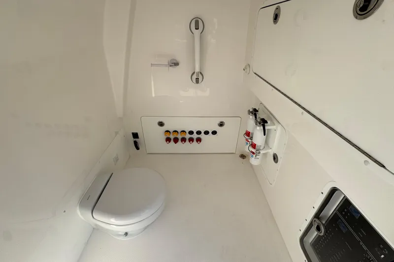  Yacht Photos Pics Interior of 2023 Invincible 35 Catamaran featuring a compact marine toilet and control panel.