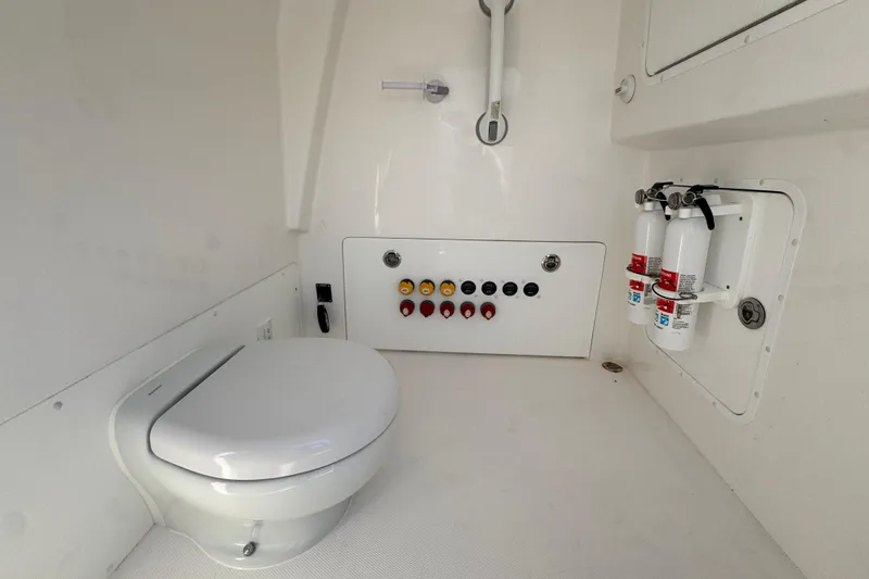  Yacht Photos Pics 2023 Invincible 35 Catamaran interior with toilet, control panel, and fire extinguishers.