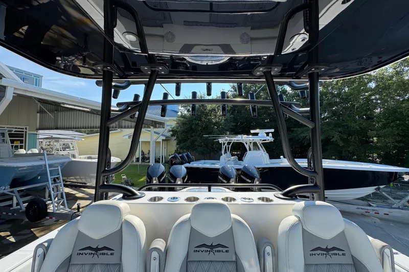  Yacht Photos Pics 2023 Invincible 35 Catamaran interior with seating and rod holders, docked at a marina.