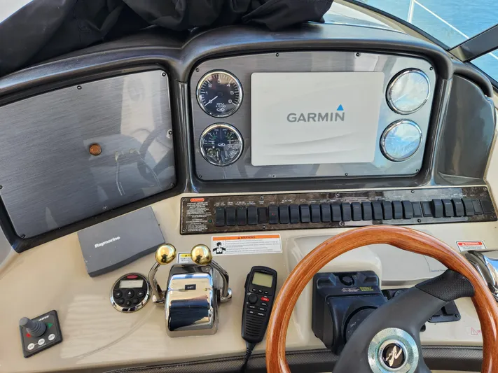  Yacht Photos Pics Helm of 2006 Sea Ray 38 Sundancer with Garmin navigation system and wooden steering wheel.