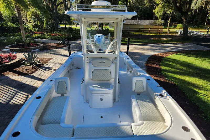  Yacht Photos Pics 2020 Caymas 28 HB boat with white seating, parked in a lush garden setting.