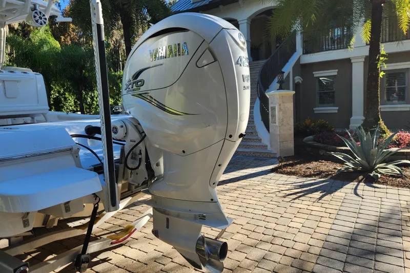  Yacht Photos Pics 2020 Caymas 28 HB boat with Yamaha XTO 425 outboard engine in a sunny driveway.