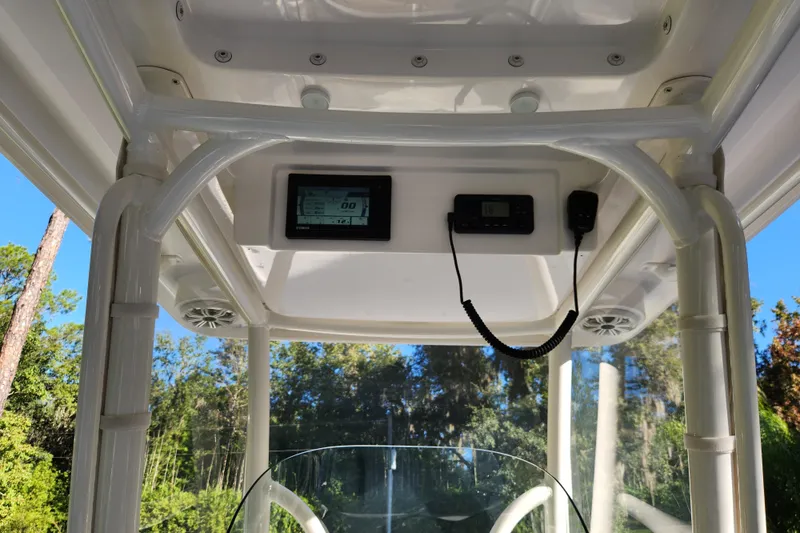  Yacht Photos Pics 2020 Caymas 28 HB boat console with electronics and speakers, surrounded by trees.