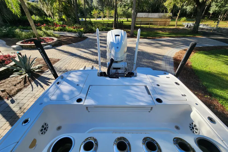  Yacht Photos Pics 2020 Caymas 28 HB boat with outboard motor in a landscaped driveway.