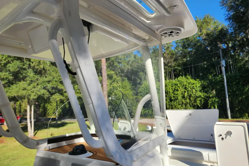  Yacht Photos Pics 2020 Caymas 28 HB boat interior with canopy and seating, surrounded by lush greenery.