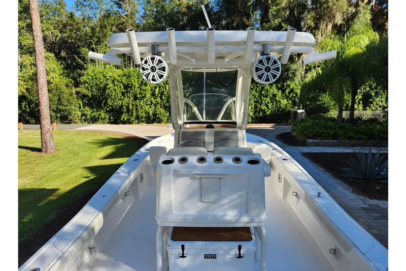  Yacht Photos Pics 2020 Caymas 28 HB boat with rod holders and speakers, set in a lush garden.