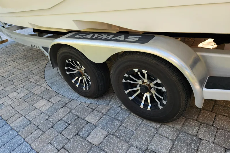  Yacht Photos Pics Trailer wheels of a 2020 Caymas 28 HB boat on a paved surface.