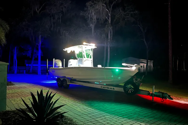  Yacht Photos Pics 2020 Caymas 28 HB boat illuminated with colorful lights on a trailer at night.