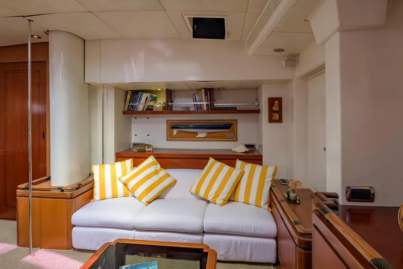 Billy Budd II Yacht Photos Pics Luxurious yacht interior with striped cushions, wooden accents, and built-in shelves. Royal Huisman 112' Custom, 1994.