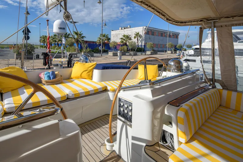 Billy Budd II Yacht Photos Pics Luxurious 1994 Royal Huisman 112' Custom yacht with striped seating and sunny marina view.