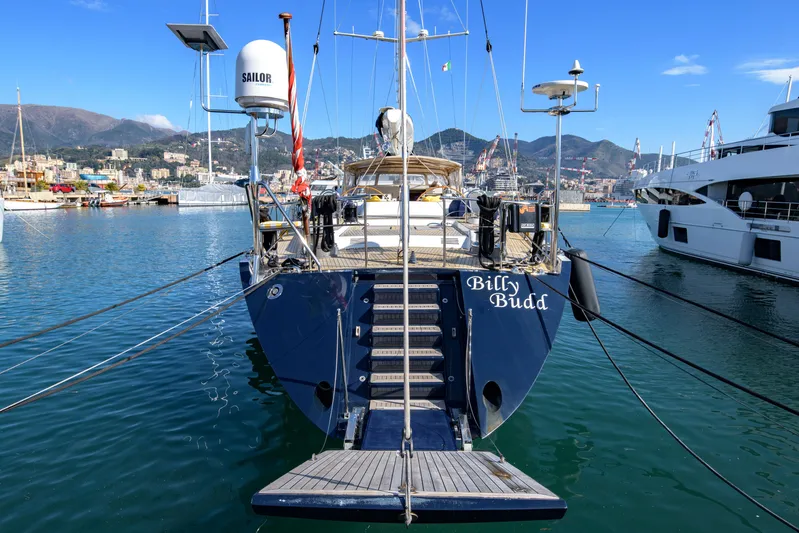 Billy Budd II Yacht Photos Pics Royal Huisman 112' Custom yacht, 1994, docked in a scenic marina with mountains in the background.