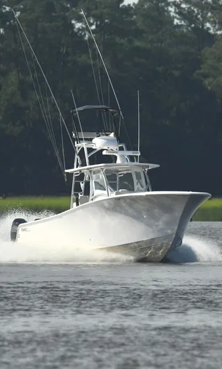  Yacht Photos Pics 2022 Front Runner 39 Center Console boat cruising on water with forest background.