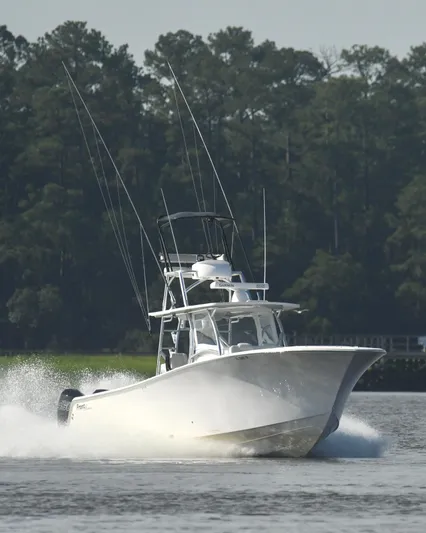  Yacht Photos Pics 2022 Front Runner 39 Center Console boat cruising on water with forest background.