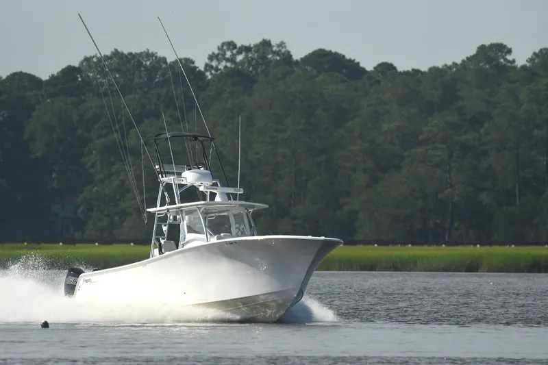  Yacht Photos Pics 2022 Front Runner 39 Center Console boat cruising on a calm lake with forest backdrop.