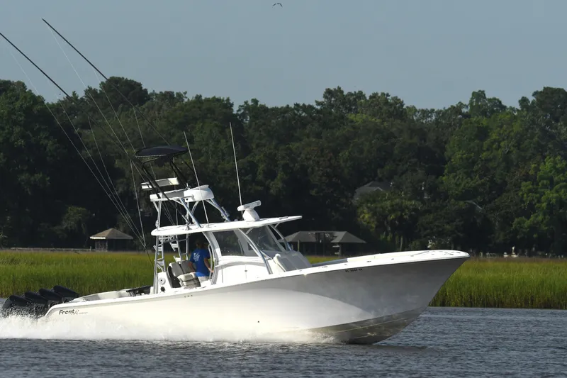  Yacht Photos Pics 2022 Front Runner 39 Center Console boat cruising on a river with lush green background.