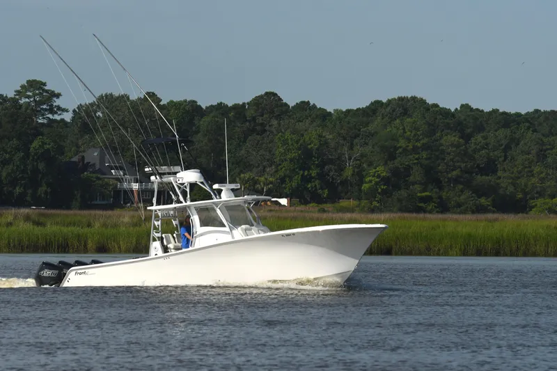  Yacht Photos Pics 2022 Front Runner 39 Center Console boat cruising on a calm river with lush green background.