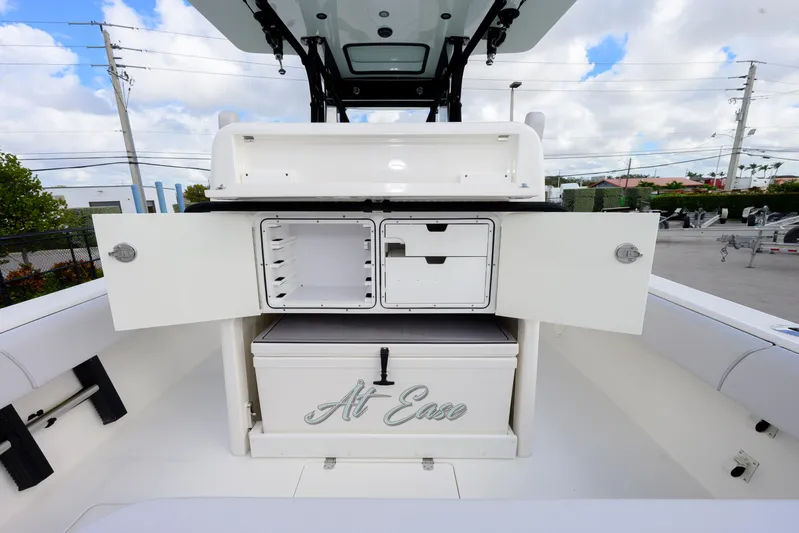 Seavee Yacht Photos Pics 2023 SeaVee 290B boat interior with open storage compartments and cooler labeled "At Ease."