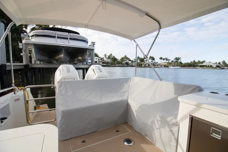  Yacht Photos Pics 2025 MJM 38 X boat with covered engines, docked by a scenic waterfront.