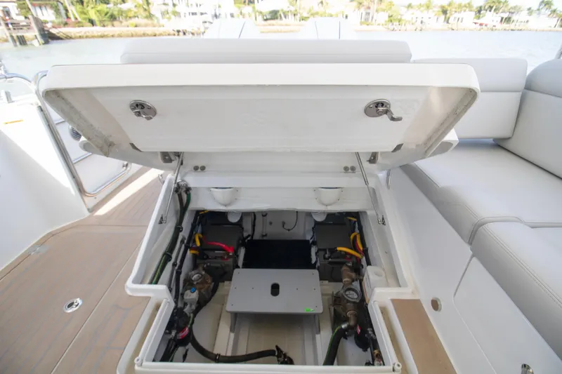  Yacht Photos Pics Open engine compartment of 2025 MJM 38 X boat, showcasing internal components and seating area.