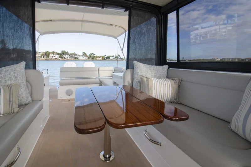  Yacht Photos Pics Luxurious interior of 2025 MJM 38 X yacht with elegant seating and wooden table.