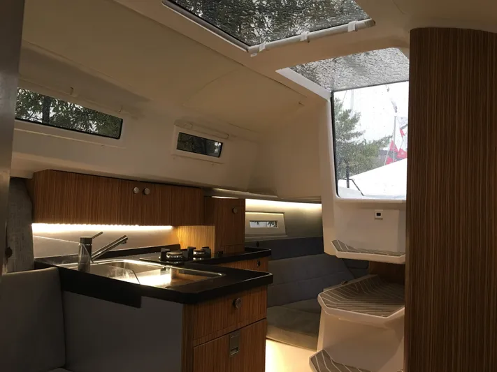  Yacht Photos Pics Modern interior of 2025 Faro Yachts 29, featuring sleek kitchen and seating area.