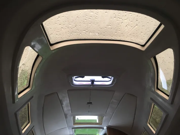  Yacht Photos Pics Interior view of 2025 Faro Yachts 29 cabin with raindrop-covered windows.