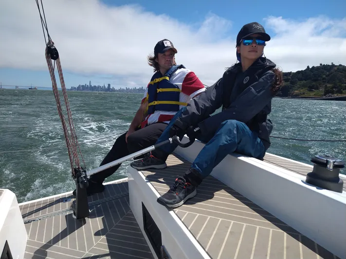  Yacht Photos Pics Two people sailing on a 2025 Faro Yachts 29 with city skyline in background.