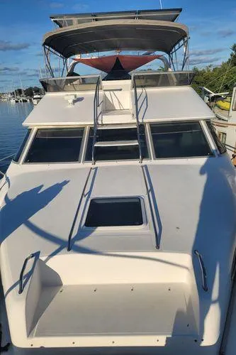 Backatcha Yacht Photos Pics 1995 Sea Ray 440 Express Bridge yacht with spacious deck and flybridge, docked in marina.