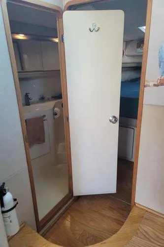 Backatcha Yacht Photos Pics Interior view of 1995 Sea Ray 440 Express Bridge, featuring a bathroom and wooden flooring.