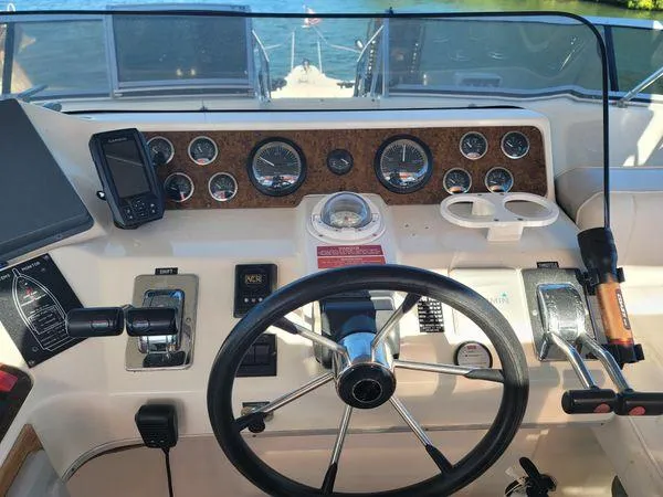 Backatcha Yacht Photos Pics 1995 Sea Ray 440 Express Bridge helm with gauges, steering wheel, and navigation equipment.