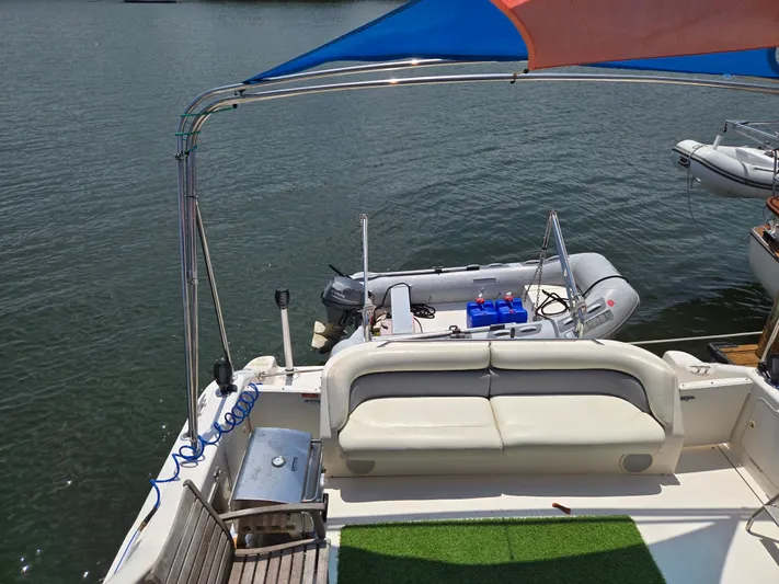 Backatcha Yacht Photos Pics 1995 Sea Ray 440 Express Bridge with seating area and small boat on water.