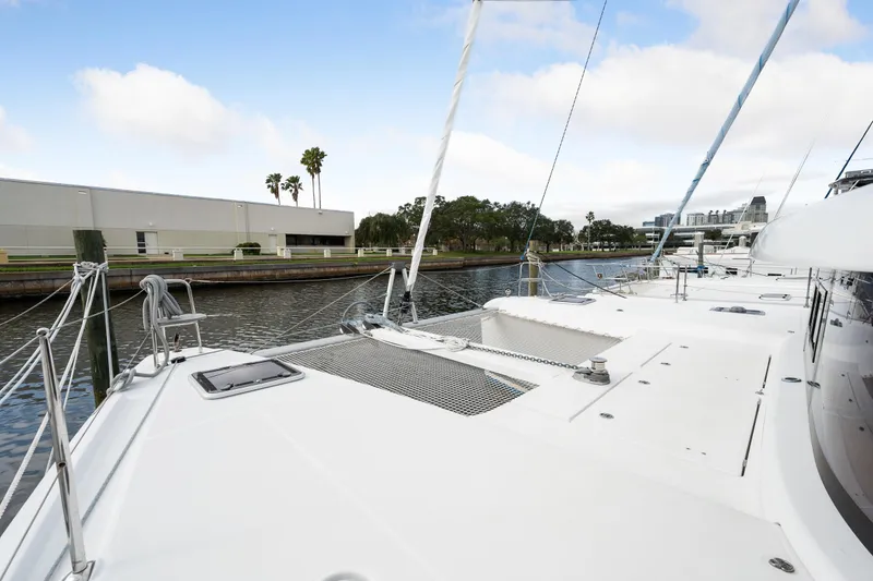 Aquaholic Yacht Photos Pics 2018 Lagoon 42 catamaran docked by a canal with clear skies.