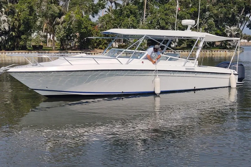 El Falcon Yacht Photos Pics 2008 Contender 35 Express Side Console boat on calm water, surrounded by lush greenery.