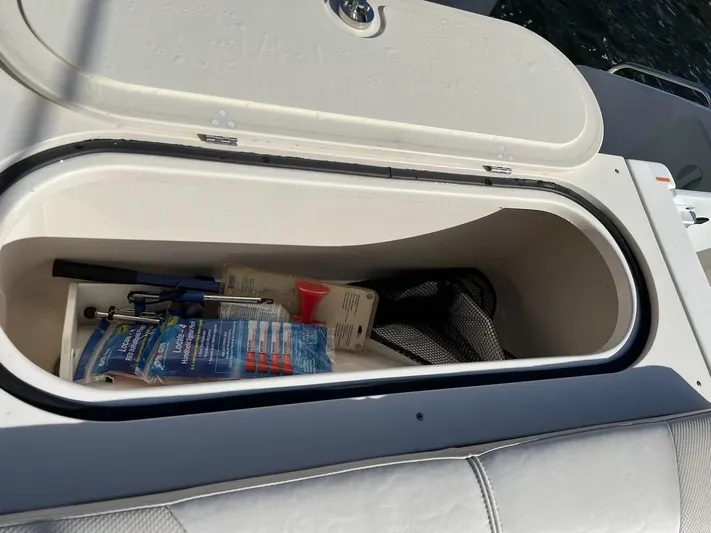 Relentless Yacht Photos Pics Storage compartment of a 2009 Pursuit S 310 Sport boat with various items inside.