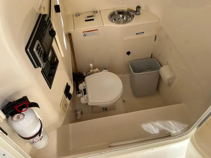 Relentless Yacht Photos Pics 2009 Pursuit S 310 Sport boat bathroom with toilet, sink, and fire extinguisher.