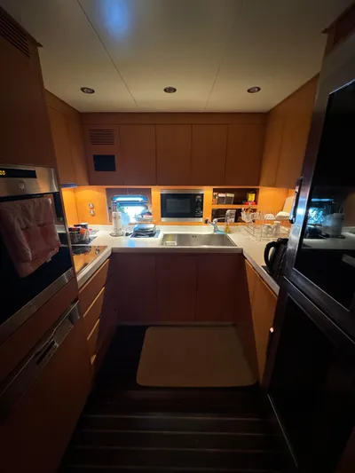 Mazag Yacht Photos Pics Compact kitchen interior on a 2007 Arno Leopard 27 yacht, featuring modern appliances and warm lighting.