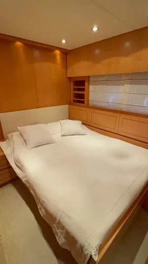 Mazag Yacht Photos Pics Luxurious bedroom interior on 2007 Arno Leopard 27 yacht, featuring elegant wood paneling and cozy bedding.